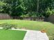 Spacious backyard featuring artificial turf, a grey stone patio, a flower pot, and wood fencing at 3808 Tupelo Branch Row, Mount Pleasant, SC 29429