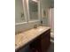 Well-lit bathroom featuring a granite countertop, modern sink fixtures and a large mirror at 3808 Tupelo Branch Row, Mount Pleasant, SC 29429