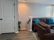 Cozy living room features a leather sofa, blue pillows, a stylish rug, and hardwood floors at 3808 Tupelo Branch Row, Mount Pleasant, SC 29429