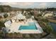 Aerial view of a community pool with a clubhouse, chairs, and palm trees surrounding the area at 3808 Tupelo Branch Row, Mount Pleasant, SC 29429