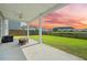 Outdoor patio with a fire pit overlooking the lawn with a pond and beautiful sky at 438 Flat Rock Ln, Summerville, SC 29486