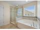 Bright bathroom featuring a glass shower and soaking tub near a window at 438 Flat Rock Ln, Summerville, SC 29486