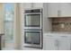 Bright kitchen featuring stainless steel double ovens and white cabinetry at 438 Flat Rock Ln, Summerville, SC 29486