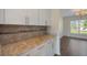 Kitchen with a quartz countertop, white cabinetry, tile backsplash, and stainless steel hardware at 438 Flat Rock Ln, Summerville, SC 29486