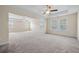 Large main bedroom with plush carpeting, a tray ceiling, fan, and plenty of natural light from multiple windows at 438 Flat Rock Ln, Summerville, SC 29486