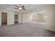 Spacious main bedroom featuring a tray ceiling, carpeting, fan, and a partial view to main bath at 438 Flat Rock Ln, Summerville, SC 29486