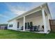 Covered back patio with a dining table, chairs, and barbecues creates a perfect outdoor entertaining space at 4407 Palm Shadow Dr, Summerville, SC 29485