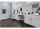 Spacious bathroom featuring double vanities, a vanity seating area, and black floor tiles at 4407 Palm Shadow Dr, Summerville, SC 29485