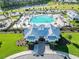 Aerial view of a luxurious community pool area with ample seating, lush landscaping, and a pristine pool house at 4407 Palm Shadow Dr, Summerville, SC 29485
