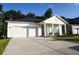 Well-manicured front lawn and long driveway leading to a two-car garage at 4407 Palm Shadow Dr, Summerville, SC 29485