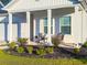 Inviting front porch with stylish seating and decorative, colorful landscaping at 4407 Palm Shadow Dr, Summerville, SC 29485