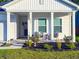 Charming front porch with cozy seating, manicured garden beds, and freshly cut grass creating a welcoming entrance at 4407 Palm Shadow Dr, Summerville, SC 29485