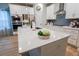 This kitchen features white cabinets, stainless steel appliances, and an island with a white countertop at 4407 Palm Shadow Dr, Summerville, SC 29485
