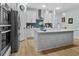 This kitchen features white cabinets, stainless steel appliances, and an island with a white countertop at 4407 Palm Shadow Dr, Summerville, SC 29485