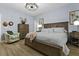 Bright main bedroom features a wooden bed frame, wood floors, and a decorative light fixture at 4407 Palm Shadow Dr, Summerville, SC 29485