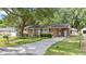 Charming brick home with green shutters, a well-manicured lawn, and a long concrete driveway at 4767 June St, North Charleston, SC 29405