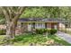 Quaint brick house featuring a covered porch, a well-maintained lawn, and neatly trimmed shrubs at 4767 June St, North Charleston, SC 29405