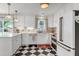 Bright kitchen features checkerboard floors, white cabinets, marble counters, and modern appliances at 5028 Victoria Ave, North Charleston, SC 29405