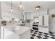 Modern kitchen features checkerboard floors, white cabinets, marble counters, and updated appliances at 5028 Victoria Ave, North Charleston, SC 29405