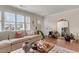 Bright and airy living room featuring a neutral sofa, natural light from windows and a gold framed mirror at 5028 Victoria Ave, North Charleston, SC 29405