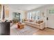 Bright and airy living room featuring a neutral sofa, natural light from windows and an arched opening to the dining room at 5028 Victoria Ave, North Charleston, SC 29405