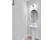 Contemporary powder room features a pedestal sink, a round mirror, modern sconces, and sleek fixtures at 515 Purple Finch Rd, Summerville, SC 29486