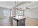 Island kitchen features stainless steel appliances, stone countertops, stylish pendant lights, and an open-concept design at 515 Purple Finch Rd, Summerville, SC 29486