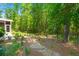 Serene backyard featuring a stone path, manicured landscaping, and a partial view of the screened-in porch at 6016 Wild Azalea Rd, Summerville, SC 29483
