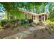 Charming home featuring a backyard with stone landscaping, a screened-in porch, and lush greenery at 6016 Wild Azalea Rd, Summerville, SC 29483