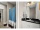 Bathroom featuring a sink and vanity with a black countertop and a full shower behind a blue shower curtain at 6016 Wild Azalea Rd, Summerville, SC 29483