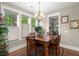 Elegant dining room with wooden table, chandelier, and large windows for natural light at 6016 Wild Azalea Rd, Summerville, SC 29483