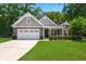 Charming single-Gathering home with an attached two car garage and well-manicured lawn at 6016 Wild Azalea Rd, Summerville, SC 29483
