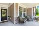 Inviting front porch with neutral siding, stone accents, and cozy seating for relaxing at 6016 Wild Azalea Rd, Summerville, SC 29483