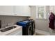Well-equipped laundry room featuring modern washer and dryer, sink, and ample storage cabinets at 6016 Wild Azalea Rd, Summerville, SC 29483