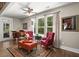 Cozy living room with plush seating, piano, and a view of the outdoors at 6016 Wild Azalea Rd, Summerville, SC 29483
