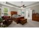 Spacious main bedroom featuring a tray ceiling, ceiling fan, and ensuite bath at 6016 Wild Azalea Rd, Summerville, SC 29483