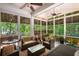 Bright sunroom with wicker furniture and screens for a relaxing indoor/outdoor space to spend an afternoon at 6016 Wild Azalea Rd, Summerville, SC 29483