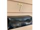 Close-up of a black metal mailbox with the house number seven in brass above it at 7 Dingle St, Charleston, SC 29403
