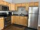 Kitchen area featuring stainless steel appliances, wooden cabinets, and a black countertop at 7 Dingle St, Charleston, SC 29403