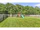 Green backyard featuring a playset, fence, and lush grass at 7644 High Maple Cir, North Charleston, SC 29418