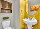 Charming powder room with yellow accent wall, decorative mirror, and modern sink at 7644 High Maple Cir, North Charleston, SC 29418
