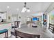 Open-concept dining area featuring gray wood floors, a modern chandelier, and flows into the living room and kitchen at 7644 High Maple Cir, North Charleston, SC 29418