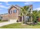 Two-story brick home featuring an attached two-car garage, well-manicured lawn and beautiful landscaping at 7644 High Maple Cir, North Charleston, SC 29418