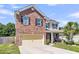Charming two-story brick home with a two-car garage, manicured lawn, and a welcoming front porch at 7644 High Maple Cir, North Charleston, SC 29418