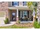 Close up of a front porch featuring two chairs and a small table surrounded by brick columns and flower beds at 7644 High Maple Cir, North Charleston, SC 29418