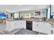 Spacious kitchen features white cabinets, granite counters, a breakfast bar, and seamlessly connects to the dining area at 7644 High Maple Cir, North Charleston, SC 29418