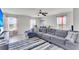 Bright living room with gray couch, ceiling fan, and many windows at 7644 High Maple Cir, North Charleston, SC 29418