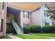 Two-story condo with wooden exterior and stairway, surrounded by lush greenery at 7950 Parklane Ct # C, North Charleston, SC 29418