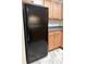 A full size black refrigerator stands next to a light wood cabinet in this kitchen view at 7950 Parklane Ct # C, North Charleston, SC 29418
