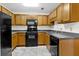 Functional kitchen featuring black appliances, wood cabinetry, and light countertops at 7950 Parklane Ct # C, North Charleston, SC 29418
